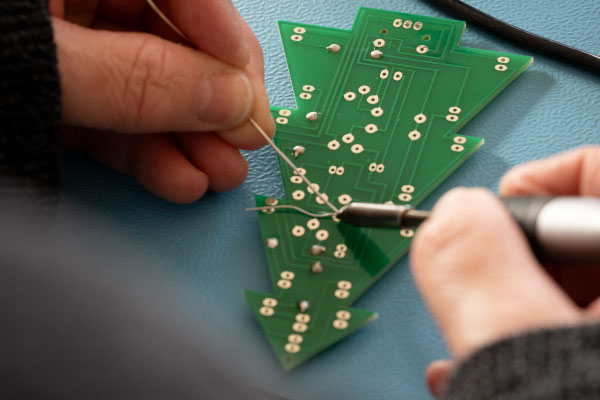 Student soldering Christmas tree kit